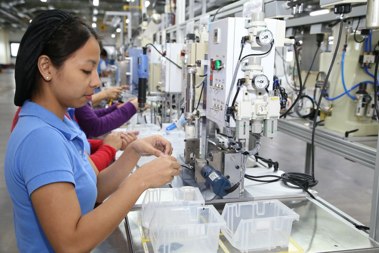 Eine ZAMA Mitarbeiterin waehrend der Fertigung eines Vergaserpumpendeckels und der Dichtheitspruefung in der Produktion im Werk in Santo Tomas, Philippinen. Hier werden  Vergaser produziert./An employee of ZAMA during the carburetor pump cover assembly and leak test in the manufacture of the facility in Santo Tomas, Philippines. Carburetors are produced here.